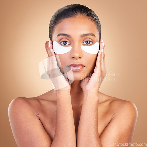 Image of Skincare, eye patch and beauty with portrait of Indian woman for facial, spa treatment and glow. Self care, cosmetics and hydration with female model on brown background for mask, product and youth