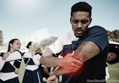 Image of Cheerleader, sports or man with elbow pain, injury or accident on field in game or training match. Red glow, fitness or cheerleading male athlete with a medical emergency, joint or muscle sprain