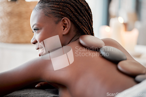 Image of Black woman, hot rocks or back massage in spa to relax for zen, meditation and wellness physical therapy treatment in resort. Beauty, salon and female on luxury healthcare, pain and spiritual peace