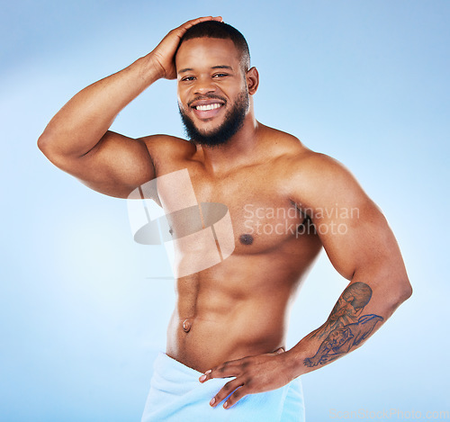 Image of Towel, shower and fitness portrait of a black man with happiness from bodybuilder muscle. Cleaning, skincare and wellness after workout and exercise with isolated, studio and blue background