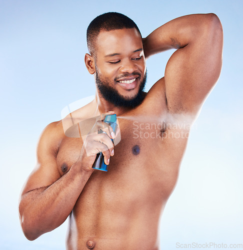 Image of Deodorant, spray and black man with smile in studio for beauty, grooming and body hygiene on blue background. Skincare, health and male spraying aerosol, fragrance and scent product for underarm