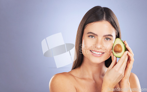 Image of Space, happy and a portrait of a woman with an avocado isolated on a blue background in a studio. Skincare, hair care and a girl with food for a diet, nutrition and glow of skin with mockup