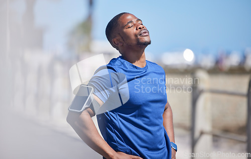 Image of Fitness, training and tired man runner outdoors for break from exercise, cardio or running on blurred background. Workout, stop and breathe by athletic male outside for marathon, run or sport routine
