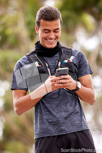 Image of Fitness, man and phone with smile for social media, communication or chatting in nature. Happy active male smiling on mobile smartphone for chat, texting or networking after outdoor workout exercise