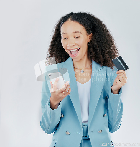 Image of Phone, credit card and online shopping with a woman customer in studio on a gray background feeling excited. Ecommerce, sale and payment with a happy female shopper enjoying retail spending