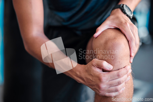 Image of Hands, knee and injury with a sports man holding his joint in pain while training in a gym for health. Fitness, accident and anatomy with a male athlete suffering from an injured body during exercise