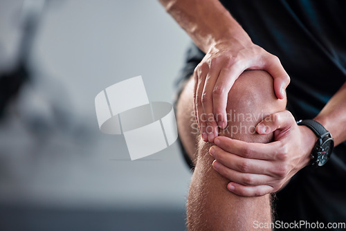 Image of Hands, knee and pain with a sports man holding a joint injury while training in a gym for health. Fitness, accident and anatomy with a male athlete suffering from an injured body during exercise