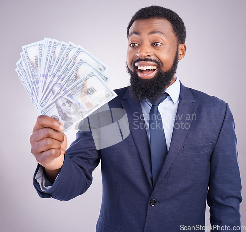 Image of Wow, cash and investment with a business black man in studio on a gray background as a lottery winner. Money, accounting and finance with a male employee holding dollar bills for the economy