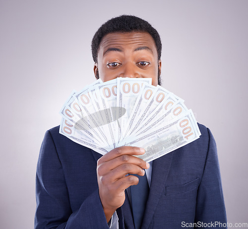 Image of Eyes, cash and investment with a business black man in studio on a gray background as a lottery winner. Money, accounting and finance with a male employee holding dollar bills for the economy