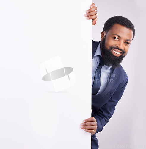 Image of Hiding, portrait and a black man standing by a wall isolated on a white background in a studio. Mockup, happy and an African corporate employee looking from a corner with space for advertising