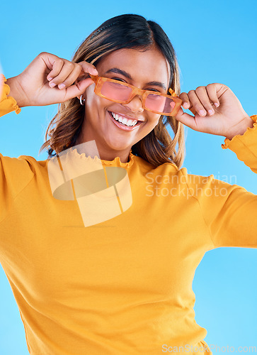 Image of Fashion glasses, teen smile and happy woman with clothes, luxury designer brand or casual outfit style. Gen z summer aesthetic, teenager face portrait and young female model on blue background studio