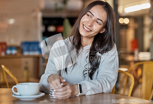 Image of Thinking, happy and a woman waiting in a coffee shop, sitting at a table to relax over the weekend. Idea, cafe and smile with an attractive young female sitting in a restaurant feeling thoughtful