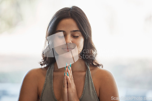 Image of Yoga meditation, prayer hands and woman in home for health, wellness and exercise. Pilates, zen chakra and calm female yogi with namaste pose for holistic training, peace and mindfulness workout.
