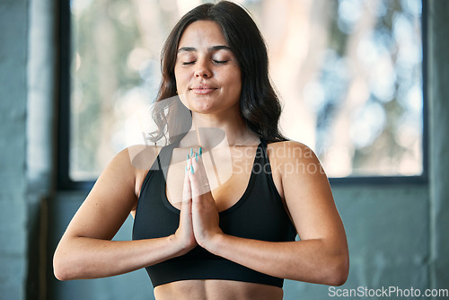 Image of Yoga meditation, prayer hands and woman in home for health, wellness and exercise. Pilates, zen chakra and calm female yogi meditate with namaste for holistic training, peace and mindfulness workout.