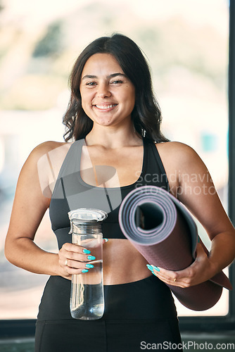 Image of Yoga mat, portrait and woman with water bottle for fitness in gym, health or wellness workout. Pilates, smile and happy female yogi with liquid for hydration and rug to start exercise or meditation.