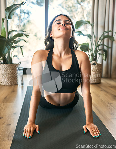 Image of Yoga meditation, cobra stretch and woman in home for health, wellness and flexibility exercise. Pilates, workout and female yogi stretching, holistic training and exercising in house for fitness.