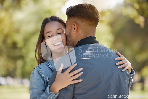 Image of Couple, outdoor and kiss on cheek with a smile for love, care and happiness together in summer. Young man and woman at nature park for affection or hug on happy and romantic date or vacation to relax