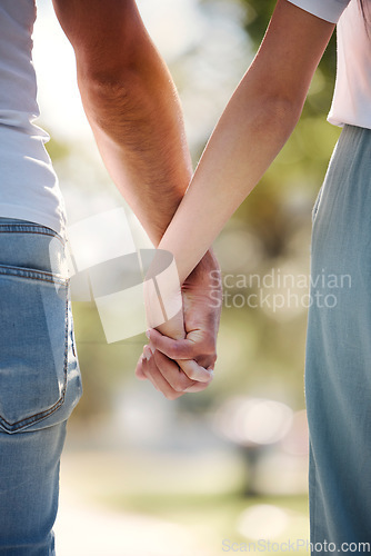 Image of Back of couple holding hands in park for love, date or marriage commitment together in garden. Closeup hand of man, woman and walking in nature, loyalty and care for partner, trust or support outdoor