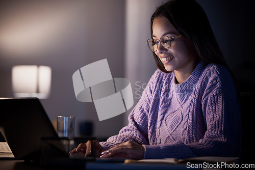 Image of Woman, happy or laptop typing in night studying, education or homework research in living room on elearning website. Smile, student or technology in dark house for knowledge or university assignment