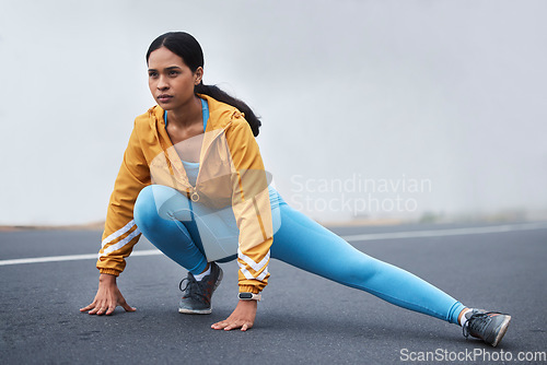 Image of Fitness leg stretching, woman and runner exercise on a outdoor road in the mountains with focus. Workout, running training and wellness of a young female ready for sports and marathon run in mist