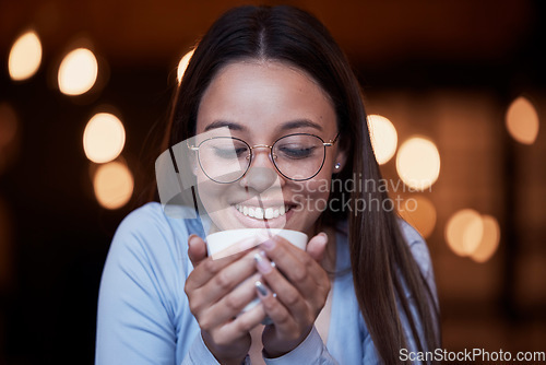 Image of Smile, cup and a woman drinking coffee at night while working late in a dark office on a deadline. Happy, mug and an attractive young female smelling the aroma or scent from a fresh mug of caffeine