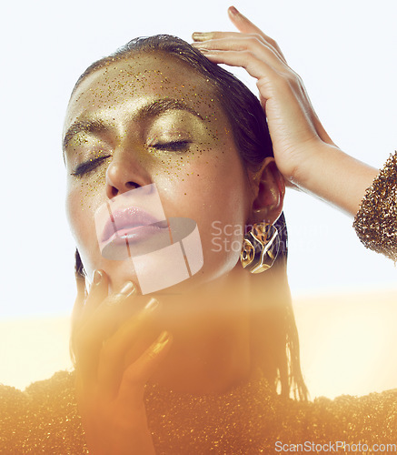 Image of Gold, woman and luxury beauty sparkle of a female with makeup and cosmetic glitter. Creative fashion, cosmetics and yellow face glow of a young person with art shimmer and golden sparkles in a studio