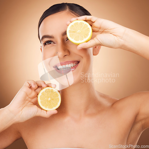 Image of Skincare, lemon and woman face cleaning of a young person with happiness in a studio. Happy, smile and dermatology of a female with cosmetics, spa aesthetic and healthy fruit for wellness facial