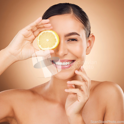 Image of Beauty, health portrait or happy woman with lemon for citrus fruit detox, healthcare or natural facial skincare routine. Vitamin c food product, studio face or female nutritionist on brown background