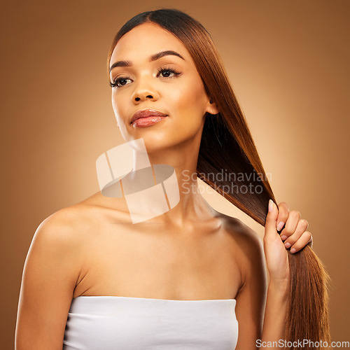 Image of Haircare, woman with strong straight hair in hand and studio space with texture and salon shine. Beauty model, healthy hairstyle and wellness, natural keratin product promotion on brown background.