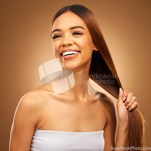 Image of Haircare, smile and woman with strong straight hair in hand and studio space with texture and salon shine. Beauty model, healthy hairstyle and natural keratin product promotion on brown background.