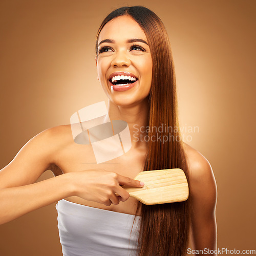 Image of Hair brush, beauty and a happy woman in studio for growth and color shine or texture. Aesthetic female thinking, brushing and laugh for natural haircare, and hairdresser or salon on brown background