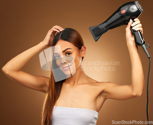 Image of Hair, hairdryer and portrait of woman in studio for growth and color shine or healthy texture. Aesthetic female hands with heat for haircare, self care and hairdresser or salon on brown background