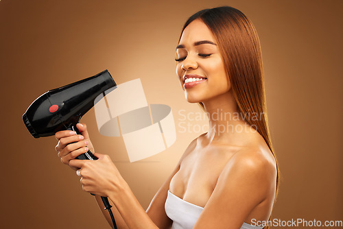 Image of Hairdryer, beauty tools and woman with smile, hair care and face with blow drying on brown background. Cosmetics, equipment and keratin treatment with mockup, happy female in studio with eyes closed