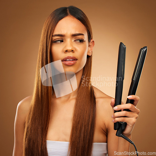 Image of Hair, flat iron and confused woman in studio for beauty, wellness and keratin treatment on brown background. Hairdresser mockup, salon and girl with doubt for heat, haircare texture and cosmetics