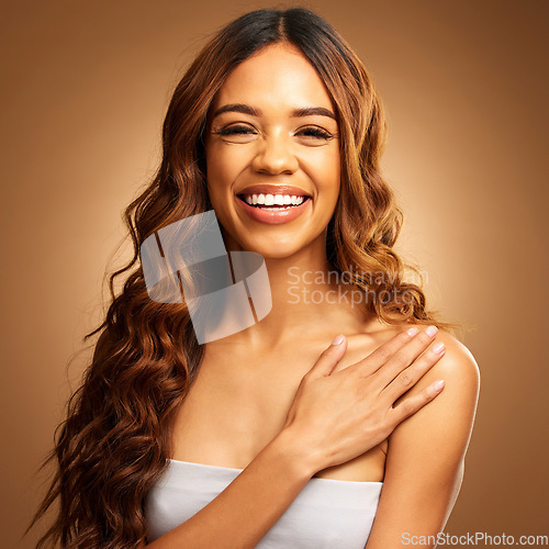 Image of Hair care, beauty and woman with smile in portrait, balayage and keratin treatment on brown background. Happy female, curly hairstyle and cosmetics, cosmetology in studio with makeup, skin and shine