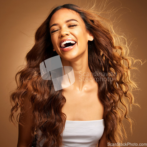 Image of Freedom, hair and excitement with a model woman on a brown background in studio for natural haircare. Happy, salon and shampoo with an attractive young female feeling excited by keratin treatment