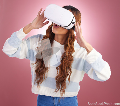Image of VR, metaverse and innovation with a woman using a headset to access the online world of gaming. AI, 3D and Virtual reality with a female gamer in studio on a pink background using future technology