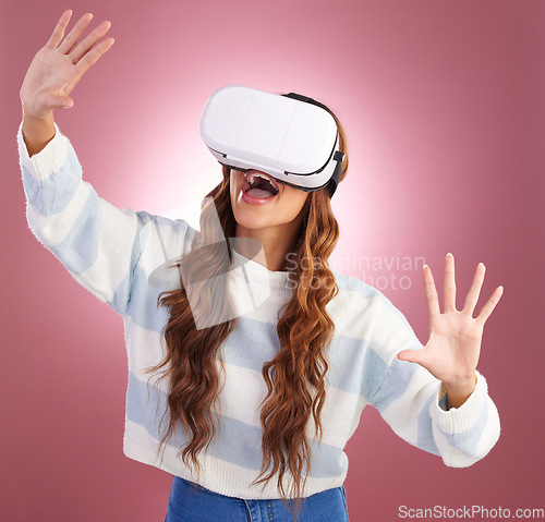 Image of VR, metaverse and gaming with a woman using a headset to access the online world of innovation. AI, 3D and virtual reality with a female gamer in studio on a pink background using future technology