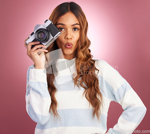 Image of Camera, portrait and woman in studio for photography, wow and surprised against pink background. Lens, photographer and face of girl posing, whistle or emoji while posing for photo on isolated mockup