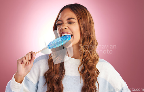 Image of Lollipop, bite and woman in studio with sugar snack, happy and having fun against a pink background. Sweet candy, satisfaction and girl eating dessert, silly and posing while isolated on mockup