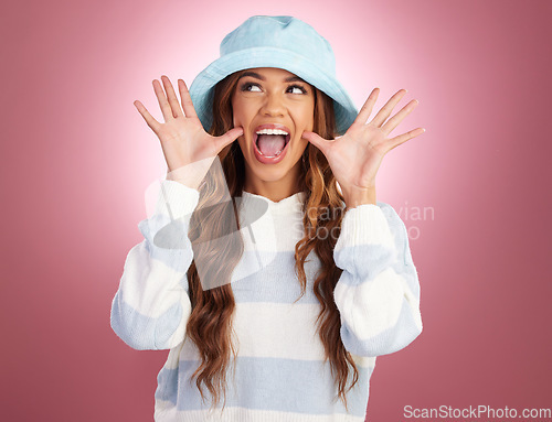 Image of Excited, comic hands and face of woman on studio background for funny, humour and emoji reaction. Beauty, fashion and happy girl model with facial expression in trendy style, cosmetics and casual hat