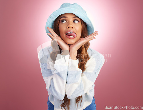 Image of Fashion, tongue out and comic face of woman on studio background for funny, humour and emoji reaction. Beauty, facial expression and happy girl model with trendy hat, cosmetics and confident style