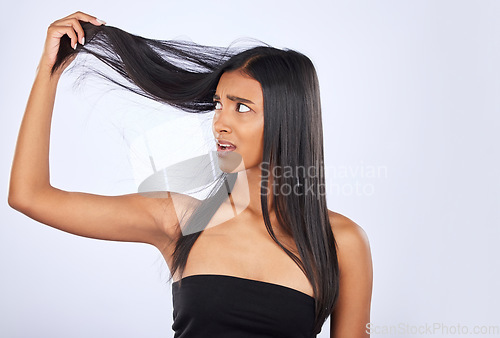 Image of Hair damage, breakage and shock of a frustrated woman isolated on a white background in studio. Bad, unhappy and an Indian girl sad about split ends, holding tangled hairstyle and frizzy haircare