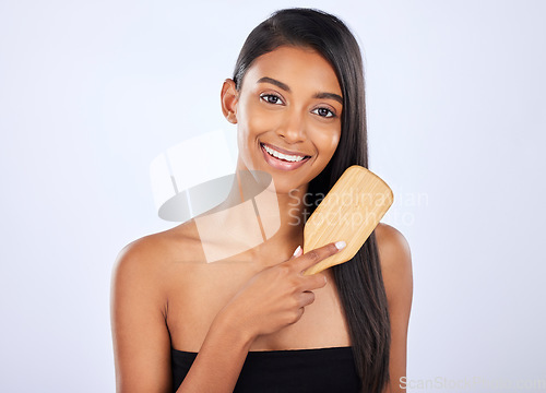 Image of Woman, portrait smile and brush for haircare, grooming or salon for keratin treatment or glow against a white studio background. Happy isolated female model smiling and brushing long hairstyle