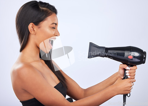 Image of Happy woman singing, hair care or dryer in studio for healthy natural shine, beauty or wellness. Funny Indian girl model, salon tools or self care equipment in grooming routine on white background