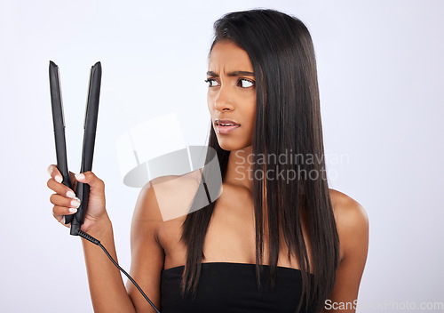 Image of Angry, woman or hair straightener for beauty self care or treatment in studio on white background. Unhappy, frustrated Indian girl model or salon equipment for ironing in grooming routine for styling