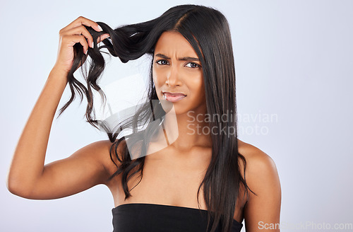 Image of Woman, problem or bad hair care portrait in studio for unhealthy damage, trouble or frizzy texture. Angry, upset or frustrated Indian girl model in self care cosmetics in grooming on white background