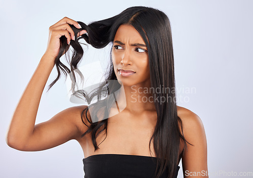 Image of Indian woman, problem or bad hair care in studio for unhealthy damage, trouble or frizzy texture. Sad, upset or frustrated young girl model in self care cosmetics in grooming on white background