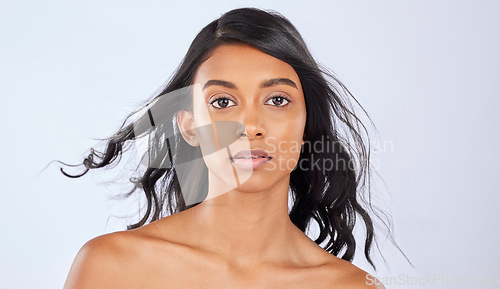 Image of Girl, hair or wind in studio portrait for growth, healthy natural shine or grooming wellness on white background. Face of glowing young Indian woman, salon spa mockup or luxury self care cosmetics