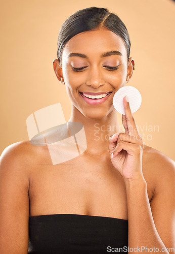 Image of Beauty, skin and face cotton of woman in studio for cosmetics, dermatology or makeup. Aesthetic female .hand with product for self care, natural makeup and facial shine results on a brown background